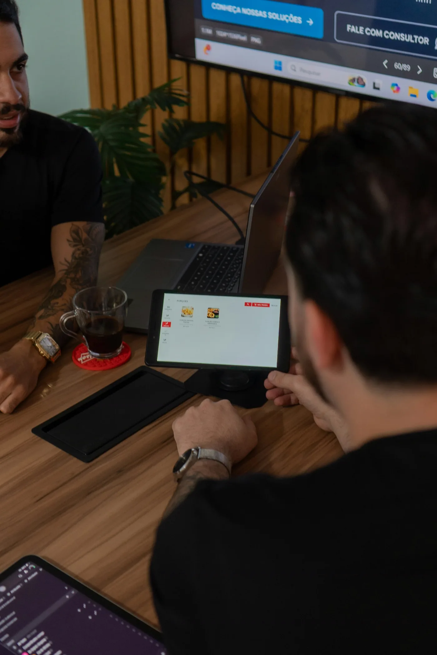 Two team members collaborating over a tablet reviewing an app prototype