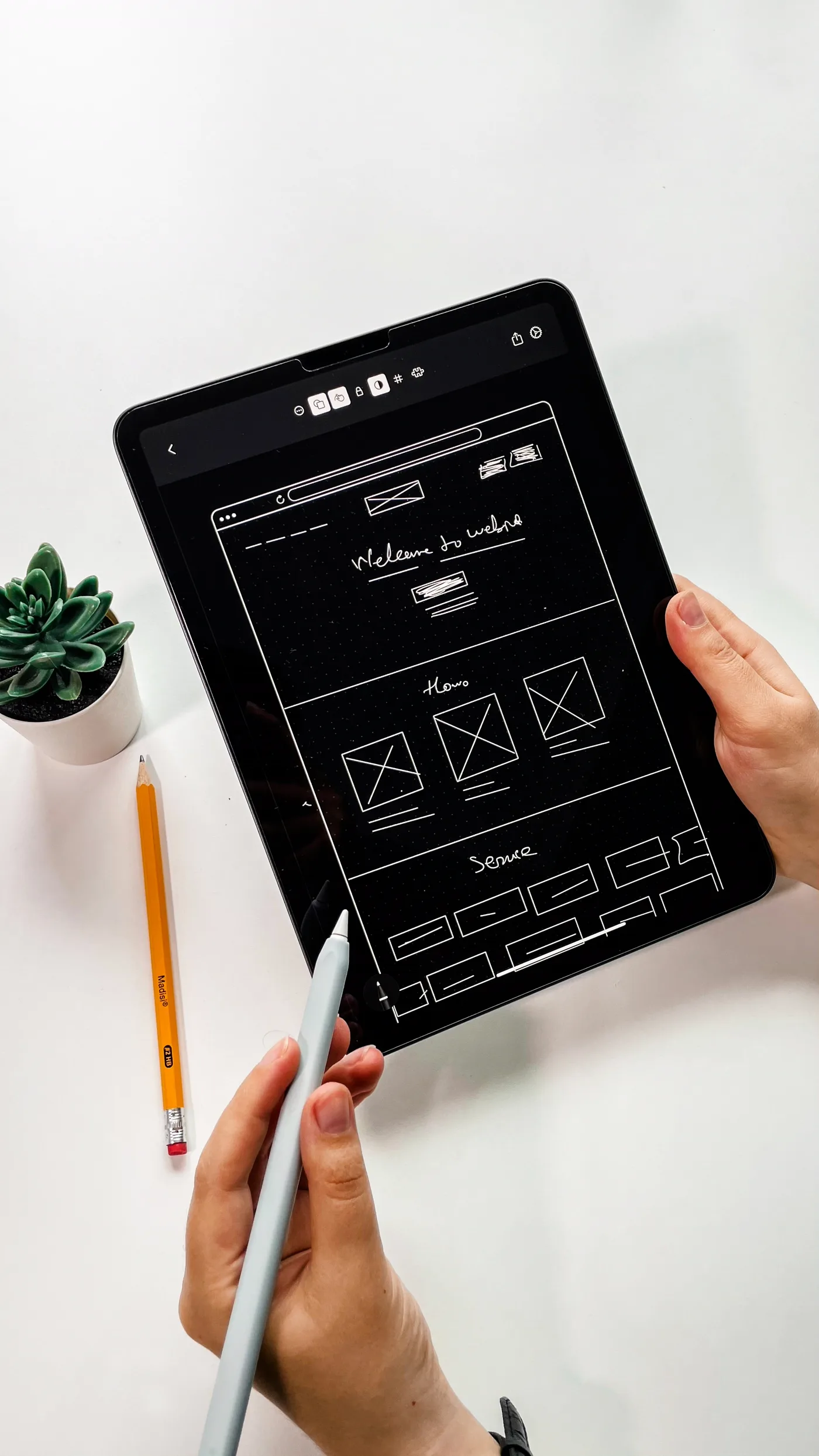 Designer reviewing a mobile app flow on a tablet in a bright studio