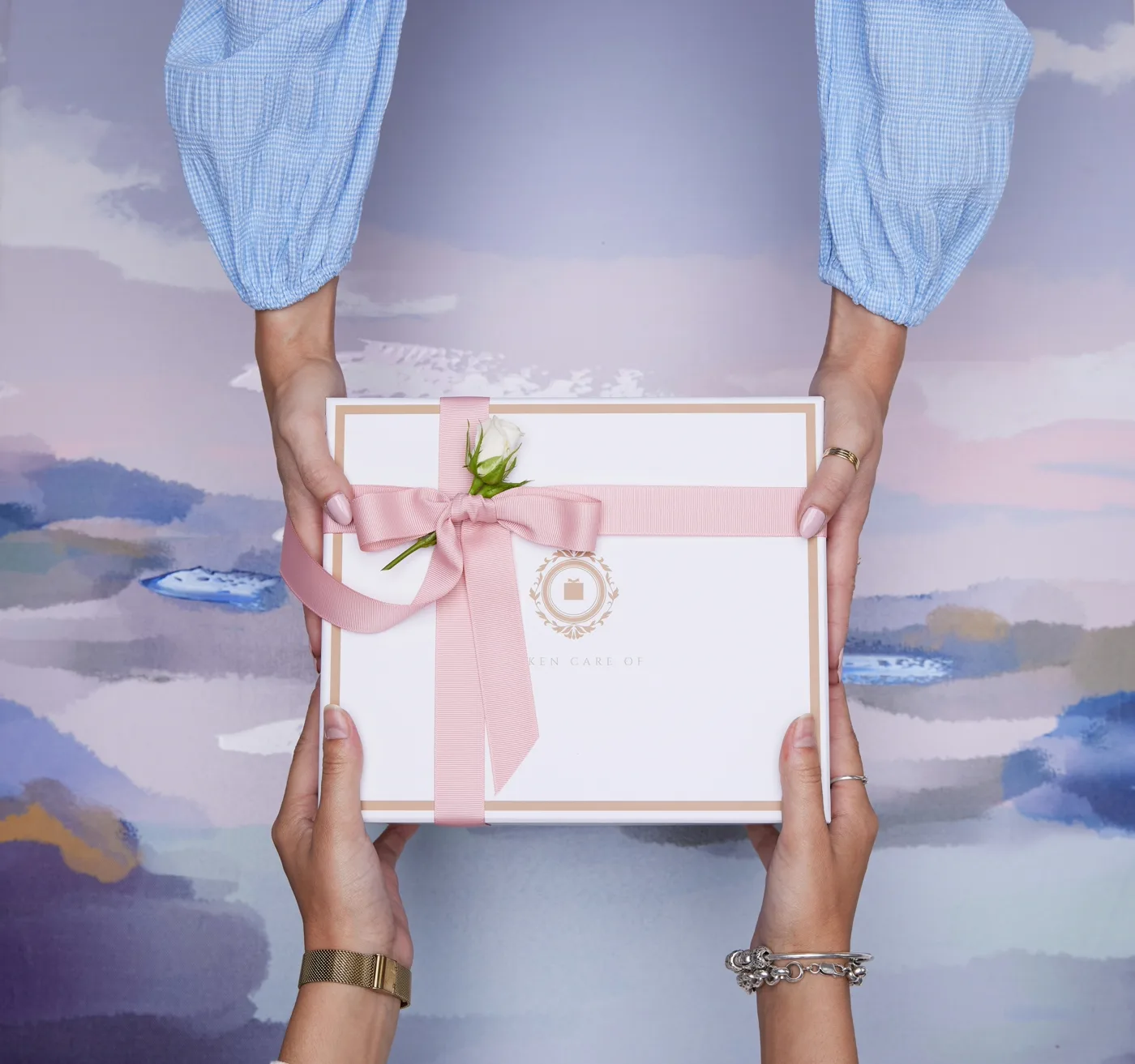 Hands opening a premium gift box with ribbon, elegant unboxing moment