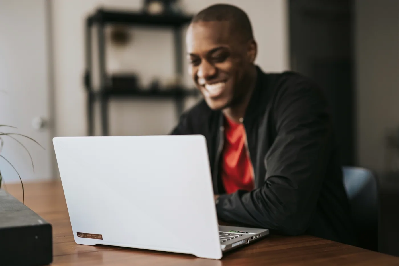 Designer in a blazer reviewing a new storefront theme on a laptop
