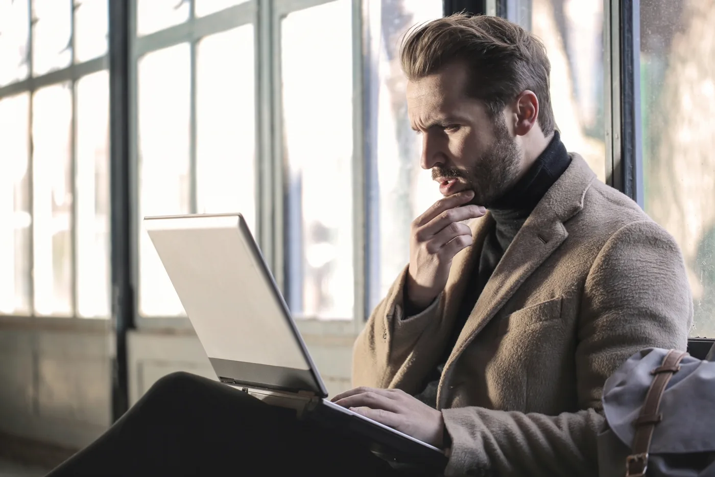 Developer thoughtfully reviewing a checkout and payments flow on a laptop