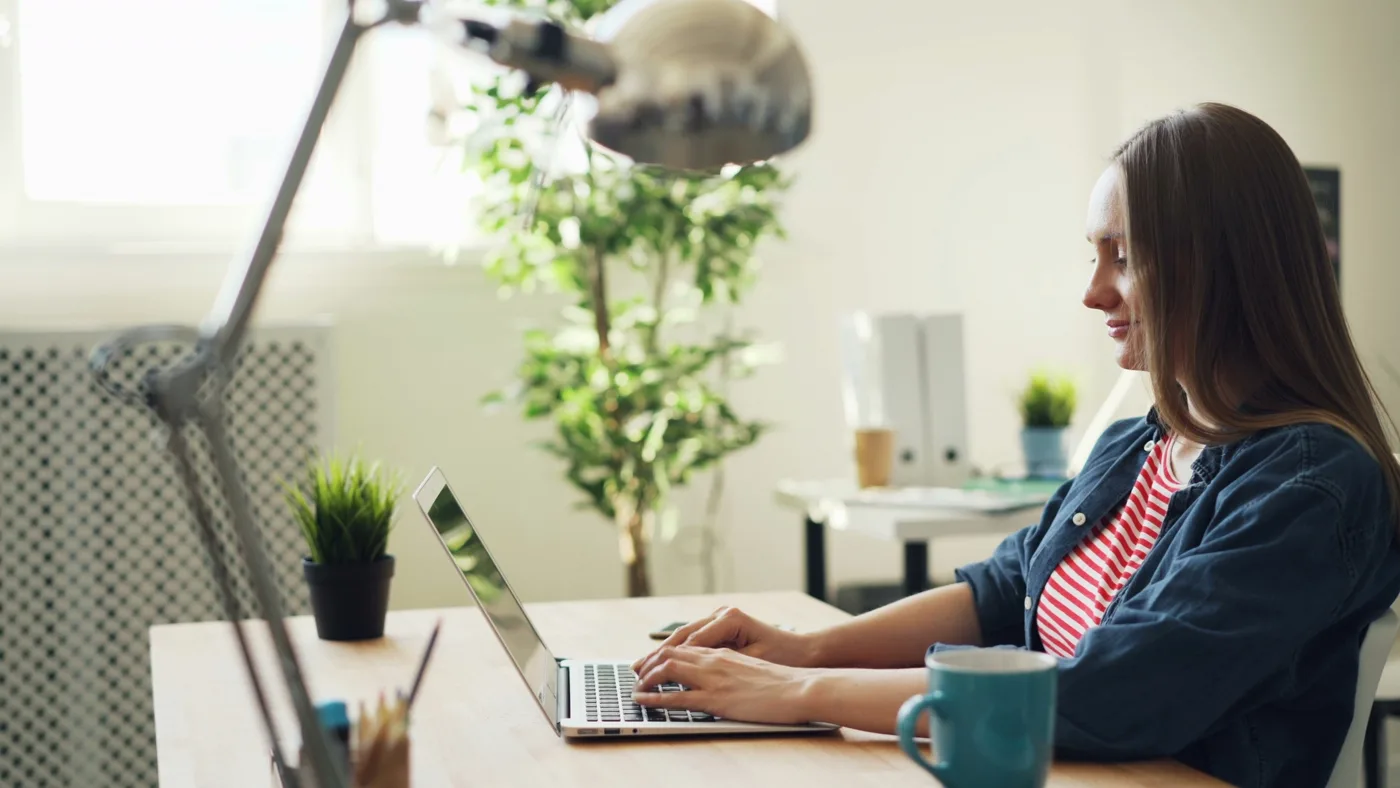 Developer at a bright office desk configuring Shopify apps and integrations on a laptop