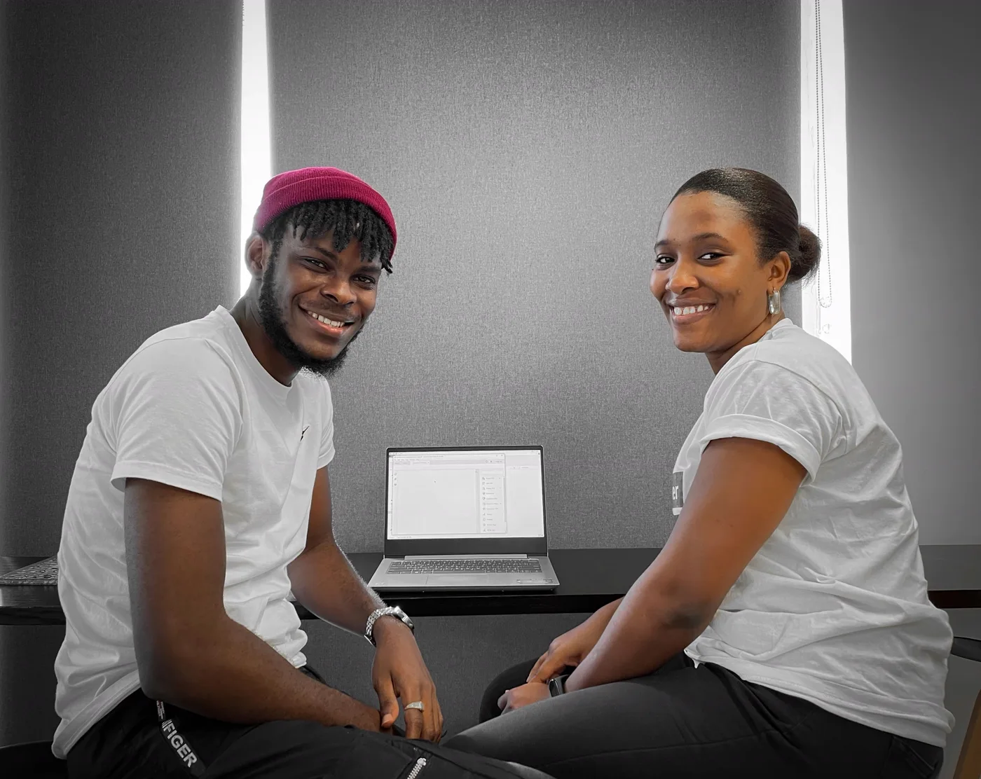 Designer and client seated together at a laptop during a usability testing and feedback session